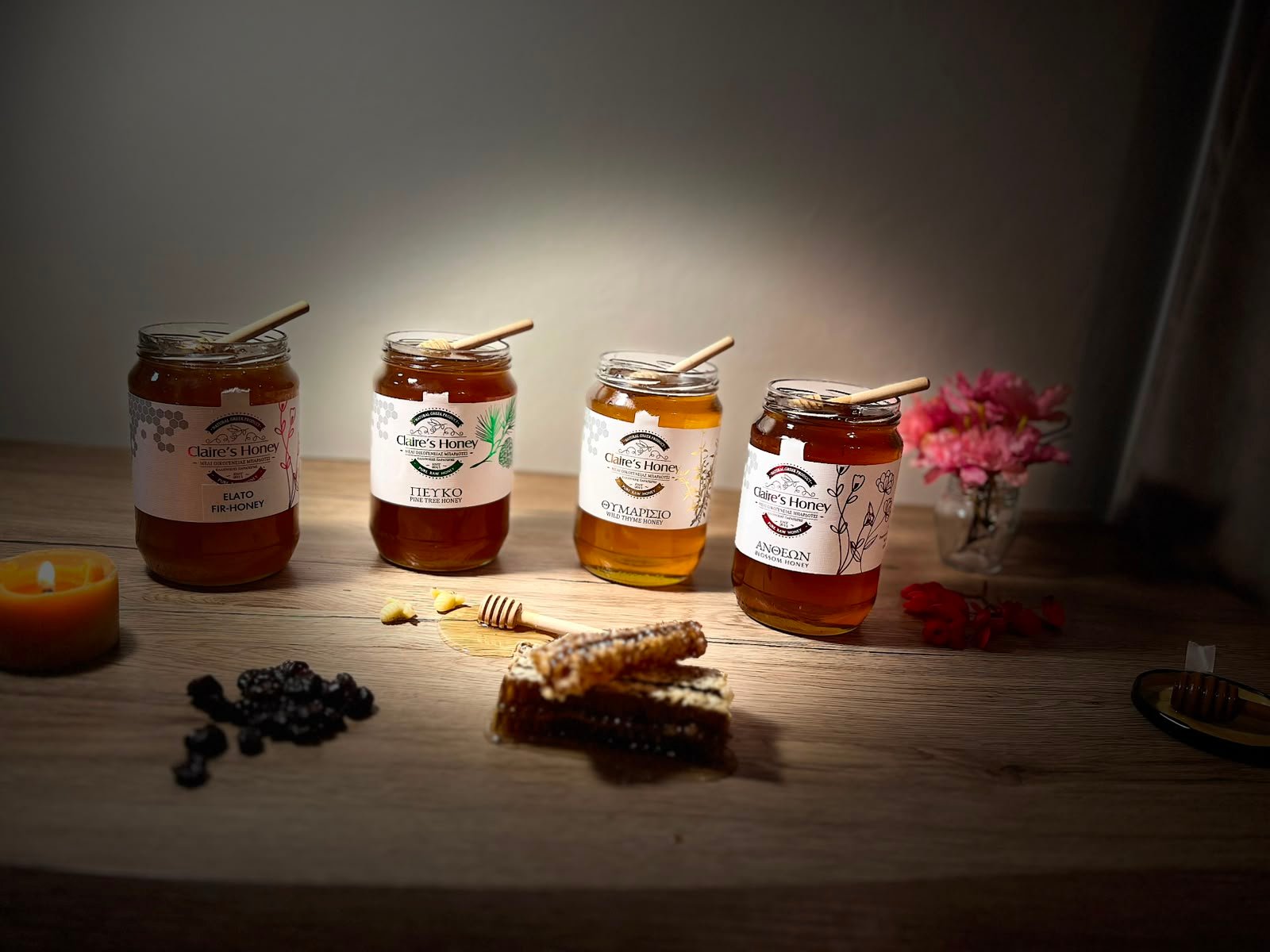 Katër varietetet e mjaltit Claire's Honey mbi tryezë druri