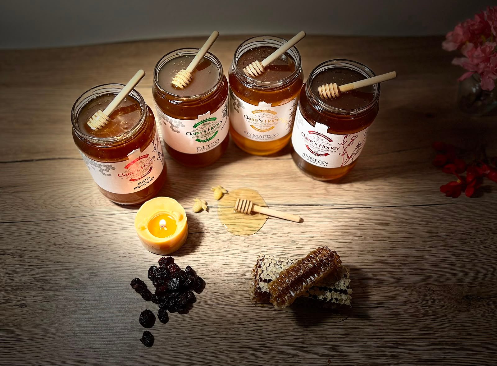 Katër varietetet e mjaltit Claire's Honey mbi tryezë druri